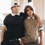 Man wearing black cotton crewneck hugging woman wearing beige cotton crewneck