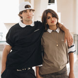 Man wearing black cotton crewneck hugging woman wearing beige cotton crewneck