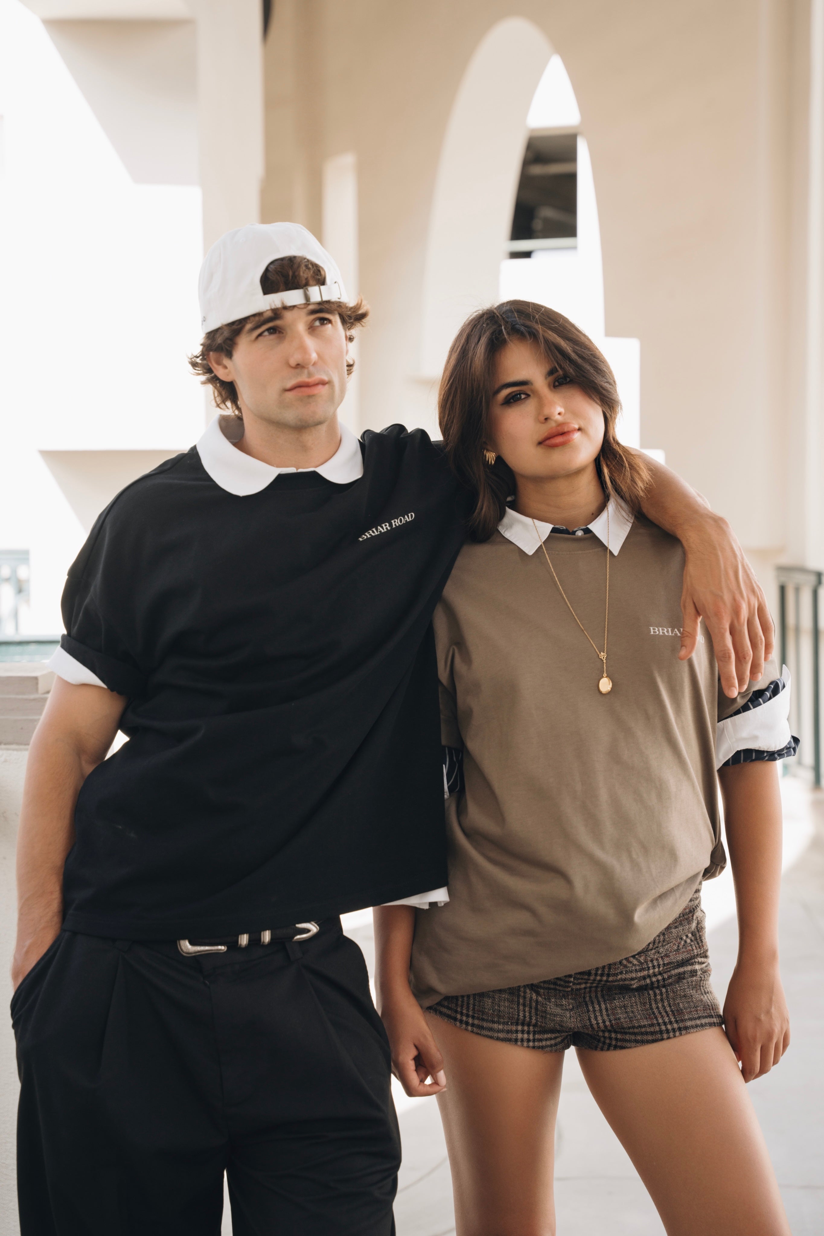 Man wearing black cotton crewneck hugging woman wearing beige cotton crewneck