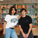 Man and woman posing casually wearing black and white crewnecks