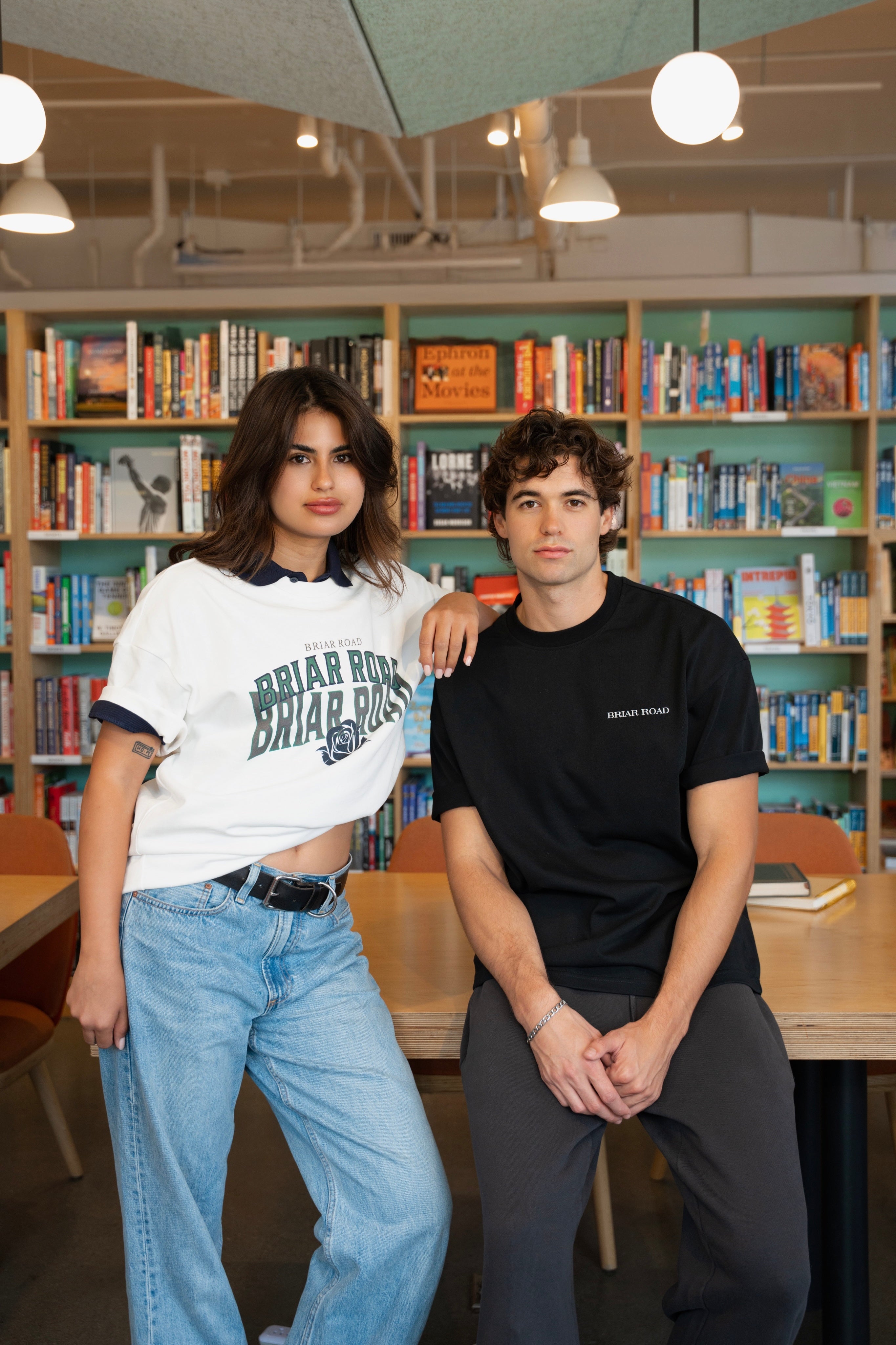 Man and woman posing casually wearing black and white crewnecks