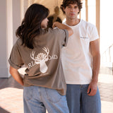 Man wearing white men's crewneck and woman wearing brown woman's crewneck
