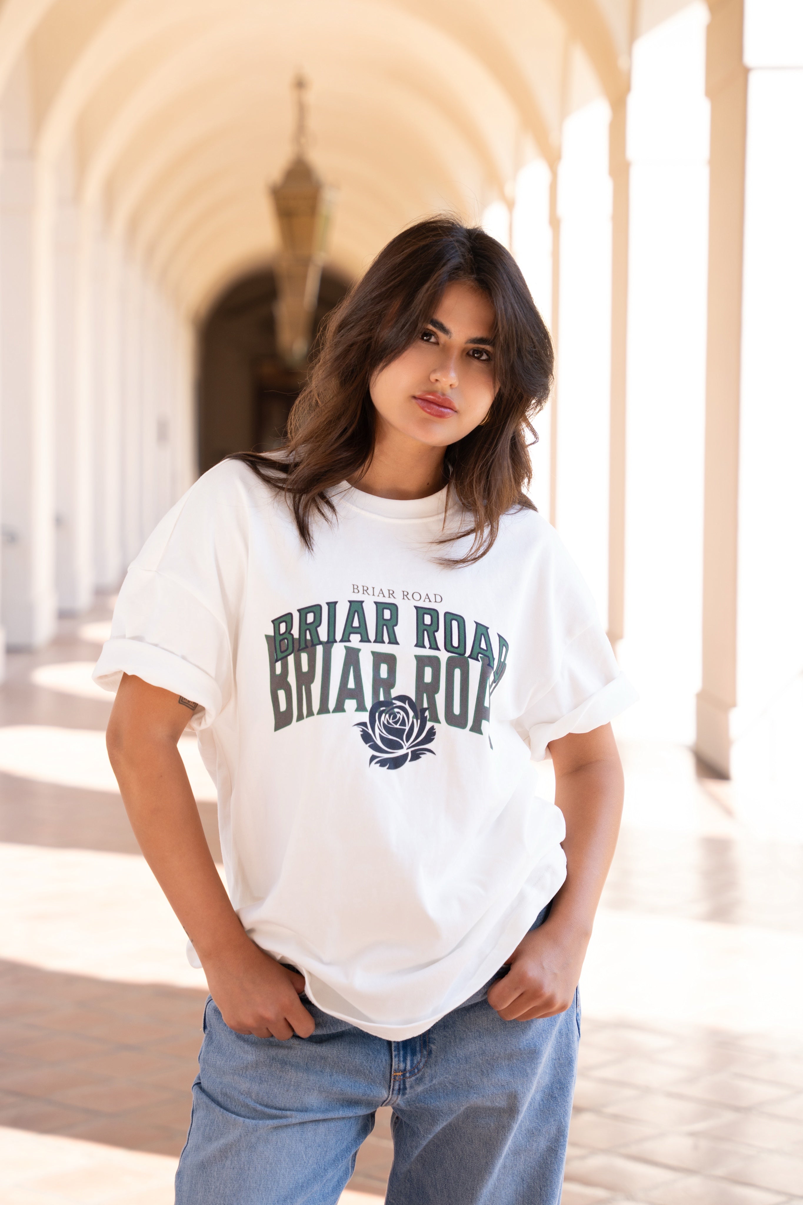 Woman wearing white oversized crewneck with Briar Road branding