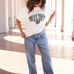 Woman looking down, wearing white oversized crewneck