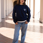Woman posing while wearing casual navy blue crewneck sweater