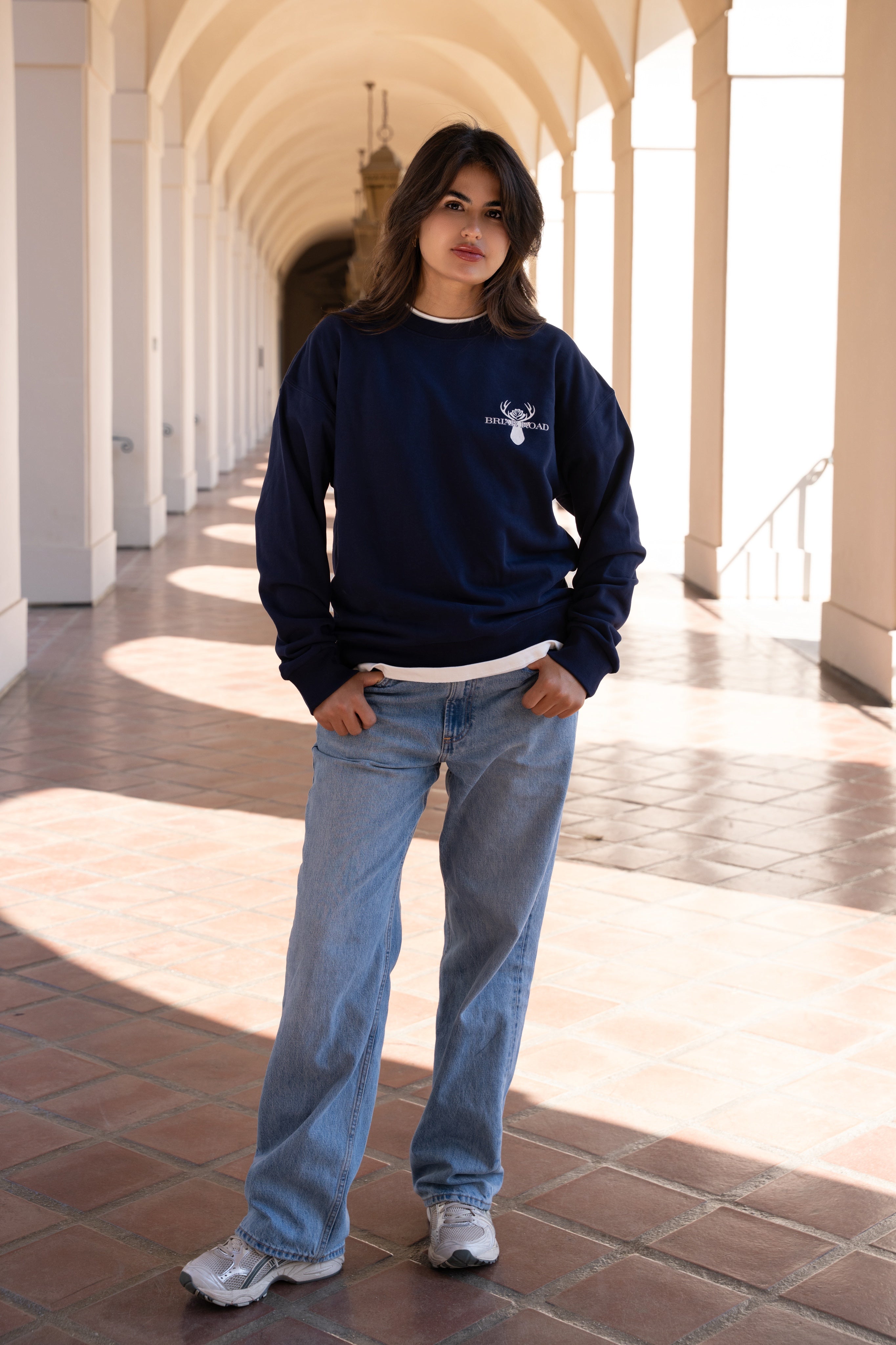 Woman posing while wearing casual navy blue crewneck sweater